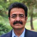 Headshot of Professor Wadhwa. A man with light brown hair and blue eyes